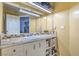 The bathroom features a tile countertop, large mirror, and under sink storage at 2450 Tournament St, Las Vegas, NV 89142