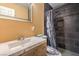 Modern bathroom with a sleek vanity, decorative mirror, and tiled shower with custom shower curtain at 2450 Tournament St, Las Vegas, NV 89142