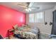 This cozy bedroom features a bright accent wall, ceiling fan, and carpeted floors at 2450 Tournament St, Las Vegas, NV 89142