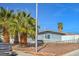 View of front yard with mature trees, rock ground cover and a single story home with fence at 2450 Tournament St, Las Vegas, NV 89142