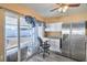 Kitchenette with white cabinets, granite counters, stainless fridge and sliding glass doors to back yard at 2450 Tournament St, Las Vegas, NV 89142