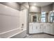 Bright bathroom featuring white cabinets, tiled floors, shower over bath, and large mirrors at 2555 Hampton Rd # 4204, Henderson, NV 89052