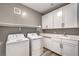 Well-lit laundry room with white cabinets, countertop, sink, and modern washer and dryer at 2555 Hampton Rd # 4204, Henderson, NV 89052