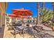 Elegant patio with tables, chairs, and red umbrellas, offering a relaxing space near the pool area at 2555 Hampton Rd # 4204, Henderson, NV 89052