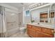 Clean bathroom features a tub, shower, and wooden vanity with a well-lit mirror at 2628 Showcase Dr, Las Vegas, NV 89134