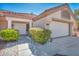 Charming home featuring a manicured front yard with lush bushes, a two-car garage, and a welcoming front entrance at 2628 Showcase Dr, Las Vegas, NV 89134