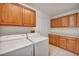 Convenient laundry room equipped with a washer, dryer, and ample storage cabinets at 2628 Showcase Dr, Las Vegas, NV 89134