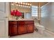 Bathroom featuring wood cabinets, glass block window and glass enclosed shower at 2872 Sumter Valley Cir, Henderson, NV 89052