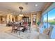 Formal dining room featuring elegant chandelier, wood table and lush outdoor views at 2872 Sumter Valley Cir, Henderson, NV 89052