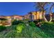 A single story home surrounded by dark green vegetation at dusk at 2872 Sumter Valley Cir, Henderson, NV 89052