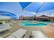 The resort-style pool is lined with lounge chairs and blue umbrellas for residents to relax by at 2872 Sumter Valley Cir, Henderson, NV 89052
