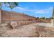 Unfinished backyard featuring a tall brick wall and desert landscaping possibilities at 3417 Steppe St, North Las Vegas, NV 89032