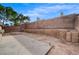 Backyard with concrete patio, brick wall, and landscape at 3417 Steppe St, North Las Vegas, NV 89032