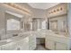 Bathroom with dual sinks, large mirror and vanity with white countertops and cabinets at 3417 Steppe St, North Las Vegas, NV 89032