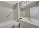 Well-lit bathroom featuring a shower-tub combo and a white single sink vanity at 3417 Steppe St, North Las Vegas, NV 89032