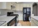 Bright kitchen with white countertops, black appliances, light cabinetry, and tan tiled flooring at 3417 Steppe St, North Las Vegas, NV 89032