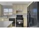 Well-equipped kitchen with black appliances, white countertops, and cream-colored cabinets at 3417 Steppe St, North Las Vegas, NV 89032