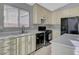 Charming kitchen with white countertops, black appliances, light cabinetry, and stainless steel fixtures at 3417 Steppe St, North Las Vegas, NV 89032