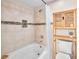 Bright bathroom featuring a tub with a shower and linen storage with wood accents at 353 Seine Way # 0, Henderson, NV 89014