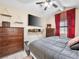 Bedroom featuring wood furniture, red curtains, and a mounted TV for entertainment at 353 Seine Way # 0, Henderson, NV 89014