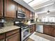This kitchen includes a tile backsplash, granite countertops, stainless steel appliances, and dark wood cabinetry at 353 Seine Way # 0, Henderson, NV 89014