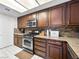 This kitchen includes granite countertops, stainless steel appliances, a microwave, and dark wooden cabinetry at 353 Seine Way # 0, Henderson, NV 89014