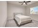 Bright bedroom with a ceiling fan, plush gray carpet, and a window with natural light at 4472 Sapphire Moon Ave, North Las Vegas, NV 89084