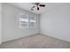 Neutral carpeted bedroom offers a ceiling fan and two windows with blinds, creating a serene atmosphere at 470 Dorchester Bend Ave # 3, North Las Vegas, NV 89032
