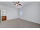 Neutral carpeted bedroom with ceiling fan, window, and ensuite bathroom entrance adds to the appeal at 470 Dorchester Bend Ave # 3, North Las Vegas, NV 89032