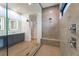 The bathroom has a large glass shower with gray tile, dual vanity with modern fixtures, and wood floors at 477 Highview Ridge Ave, Las Vegas, NV 89138