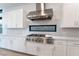 Gourmet kitchen with stainless vent hood, stone backsplash, and professional gas range at 477 Highview Ridge Ave, Las Vegas, NV 89138