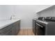 The laundry room has a white quartz counter, modern sink, and gray front-loading washer and dryer at 477 Highview Ridge Ave, Las Vegas, NV 89138