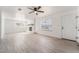 Spacious living room with a ceiling fan, stone fireplace, front door, and large windows at 4980 Becky Pl, Las Vegas, NV 89120
