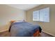 Bedroom with a wooden bed frame with a blue comforter and a window at 5065 Atherton St, Las Vegas, NV 89120