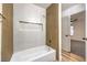 Bright bathroom features a shower-tub combo with tile surround, gold hardware, and natural wood accents at 5101 Village Dr, Las Vegas, NV 89142