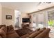 Comfortable living area featuring neutral walls, a brown sectional sofa, and sliding glass doors to the patio at 5932 Lamotte Ave, Las Vegas, NV 89141