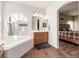 Main bathroom with garden tub, natural light, and vanity with mirror at 5932 Lamotte Ave, Las Vegas, NV 89141