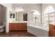 Bright bathroom featuring a soaking tub, and large vanity with generous mirror at 5932 Lamotte Ave, Las Vegas, NV 89141