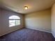 Neutral bedroom featuring plush carpet and an arched window letting in natural light at 6093 Crown Palms Ave, Las Vegas, NV 89139