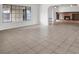 Open living room with tile flooring, natural light from a large window, and brick fireplace feature at 6130 Tara Ave, Las Vegas, NV 89146