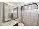Cozy bathroom featuring a framed mirror, sink, toilet, and patterned shower curtain for added privacy at 6325 Miraloma St, Las Vegas, NV 89108