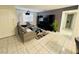A bright living room with tile flooring, a grey sofa and large television at 6750 Del Rey Ave # 133, Las Vegas, NV 89146