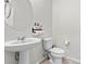 Bright half-bathroom features white fixtures, modern hardware, and sleek pedestal sink at 6957 Antequera St, Las Vegas, NV 89149