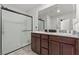 Bathroom featuring double sinks, a walk-in shower with glass doors, and modern fixtures at 6957 Antequera St, Las Vegas, NV 89149