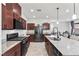 Modern kitchen with stainless steel appliances, granite countertops, and stylish dark wood cabinetry at 6957 Antequera St, Las Vegas, NV 89149