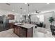 Bright kitchen with a large island, stainless appliances, and stylish pendant lighting, open to living space at 6957 Antequera St, Las Vegas, NV 89149