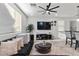 Bright living room with modern ceiling fan, large TV, and comfortable seating area with neutral tones at 6957 Antequera St, Las Vegas, NV 89149