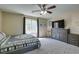 Comfortable bedroom with a ceiling fan, window, dresser, and a decorative quilt on the bed at 7113 Forest Heights Ct, Las Vegas, NV 89166