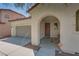 Exterior view of the front door with an arched entryway, desert landscaping, and a two-car garage at 7113 Forest Heights Ct, Las Vegas, NV 89166
