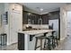 Contemporary kitchen with stainless steel appliances, dark cabinets, a breakfast bar, and wood-look floors at 7113 Forest Heights Ct, Las Vegas, NV 89166